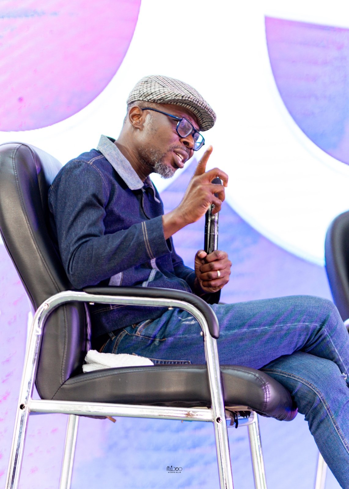 Bernard sharing insights during a seated conference conversation